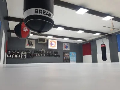 Smooth white PVC floor cover in a gym, secured to the wall with zig-zagging bungee cord through eyelets in the cover.