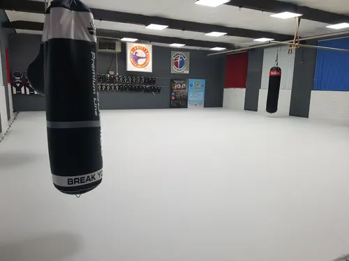 Red and blue boxing ring floor cover next to each other with rope covers and corner posts